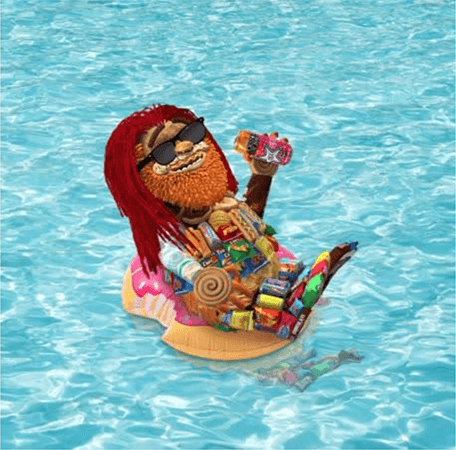 Image of Toomgis on a donut pool floatie in a pool while holding a Rockstar energy drink.